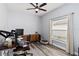 Home Office featuring a ceiling fan, window with curtains, and hardwood floors at 9067 Stonebury Way, Orlando, FL 32832