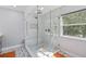 Glass enclosed shower with bench seating, decorative tile, and hand held shower feature at 9067 Stonebury Way, Orlando, FL 32832