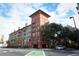 Attractive condo building exterior with balconies, colorful facade, palm trees and street view on a sunny day at 911 N Orange Ave # 143, Orlando, FL 32801
