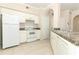 Well-lit kitchen featuring white appliances, tile flooring, and classic cabinetry at 911 N Orange Ave # 143, Orlando, FL 32801