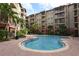 Beautiful community pool area with brick patio, palm trees, lounge chairs and well-maintained landscaping at 911 N Orange Ave # 143, Orlando, FL 32801
