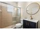 Stylish bathroom with a glass-enclosed shower, toilet, and sleek vanity with a modern round mirror at 10117 Sweetleaf St, Orlando, FL 32827