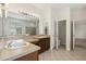 Bathroom featuring double sinks, tile flooring, and an adjacent room with a toilet and walk-in shower at 10117 Sweetleaf St, Orlando, FL 32827
