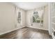 Bright bedroom with wood-look flooring, white trim, and two windows dressed with simple, white curtains at 10117 Sweetleaf St, Orlando, FL 32827