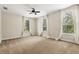 Neutral bedroom featuring carpet, three large windows with curtains, and a ceiling fan at 10117 Sweetleaf St, Orlando, FL 32827