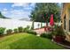 Landscaped backyard featuring a brick patio with dining set, lawn, and a white fence for privacy at 1041 Cherry Valley Way, Orlando, FL 32828