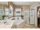 Bright bathroom with a garden tub, glass enclosed shower, and neutral tile flooring at 1041 Cherry Valley Way, Orlando, FL 32828