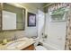 Well-lit bathroom featuring a tiled tub/shower combo, vanity sink, and framed mirror at 1041 Cherry Valley Way, Orlando, FL 32828