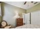 Comfortable bedroom with warm green walls, wood flooring, and a classic wooden dresser at 1041 Cherry Valley Way, Orlando, FL 32828