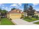 Well-maintained single-Gathering home with manicured lawn, lush landscaping, and a convenient two-car garage at 1041 Cherry Valley Way, Orlando, FL 32828