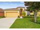 Inviting yellow home with a well-manicured lawn and a two-car garage at 1041 Cherry Valley Way, Orlando, FL 32828