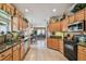 Spacious kitchen with wood cabinets, tile floor, granite countertops, and stainless steel appliances, open to dining room at 1041 Cherry Valley Way, Orlando, FL 32828