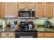 Well-equipped kitchen with granite countertops, wood cabinets, and stainless steel microwave and black glass-top range at 1041 Cherry Valley Way, Orlando, FL 32828