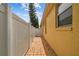 Well-maintained side yard with a brick pathway, a white fence, and vibrant landscaping at 1041 Cherry Valley Way, Orlando, FL 32828