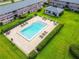 Aerial view of a large, clear pool with many lounge chairs and lush green landscaping at 1100 E Caroline St # 204, Tavares, FL 32778