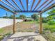 A view of the backyard, featuring a pergola and shed with lush greenery, offering a serene outdoor space at 1115 Naples Dr, Orlando, FL 32804