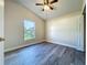 Bedroom includes gray floors, a ceiling fan, and a window overlooking the backyard at 1115 Naples Dr, Orlando, FL 32804