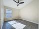 Spacious bedroom featuring wood-look floors, ceiling fan, and natural light at 1115 Naples Dr, Orlando, FL 32804