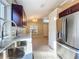 Kitchen featuring quartz countertops, stainless steel sink, and new refrigerator overlooking the living area at 1115 Naples Dr, Orlando, FL 32804