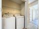 Convenient laundry room with washer, dryer, and storage shelf, located near the entrance of the house at 1115 Naples Dr, Orlando, FL 32804