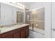 A well-lit bathroom with double sinks, granite countertops, and a tiled shower and tub at 12255 Joshua Tree Trl, Windermere, FL 34786