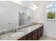 Bathroom featuring double sinks, a large mirror, and a window providing natural light at 12255 Joshua Tree Trl, Windermere, FL 34786