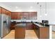 A modern kitchen features granite countertops, stainless steel appliances and wooden cabinetry at 12255 Joshua Tree Trl, Windermere, FL 34786