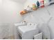 Bright laundry room with front load washer and dryer, and white wire shelving for storage at 12255 Joshua Tree Trl, Windermere, FL 34786