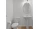 Bathroom featuring a toilet, pedestal sink, mirror and tile flooring at 12884 Penshurst Ln, Windermere, FL 34786