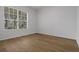 A bedroom featuring wood floors, a large window with natural light, and neutral white walls at 12884 Penshurst Ln, Windermere, FL 34786