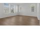 A serene bedroom featuring wood floors, three large windows with exterior views, and a tray ceiling at 12884 Penshurst Ln, Windermere, FL 34786