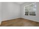 An empty bedroom with wood floors, a large window, and neutral walls offering plenty of natural light at 12884 Penshurst Ln, Windermere, FL 34786