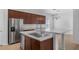 Modern kitchen featuring stainless steel appliances, an island with a white countertop, and custom cabinets at 12884 Penshurst Ln, Windermere, FL 34786