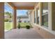 A covered patio with an outdoor view of a green yard, plants and neighboring houses at 12884 Penshurst Ln, Windermere, FL 34786