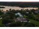 Aerial dusk shot of a neighborhood with homes overlooking a tranquil lake at 13025 Lake Roper Ct, Windermere, FL 34786