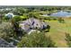 An aerial shot features a beautiful home with well-manicured lawn, screened-in porch and lakeside views at 13025 Lake Roper Ct, Windermere, FL 34786