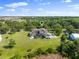 Backyard view with large lawn, screened-in porch, outdoor fire pit, and basketball court perfect for entertaining at 13025 Lake Roper Ct, Windermere, FL 34786