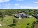 Backyard view with large lawn, screened-in porch, outdoor fire pit, and basketball court perfect for entertaining at 13025 Lake Roper Ct, Windermere, FL 34786