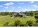 Backyard view with large lawn, screened-in porch, outdoor fire pit, and basketball court perfect for entertaining at 13025 Lake Roper Ct, Windermere, FL 34786