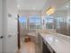 Bright bathroom featuring double sinks, arched windows, walk-in shower, and soaking tub at 13025 Lake Roper Ct, Windermere, FL 34786