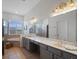 Bright bathroom features double vanity, large mirrors, and arched windows with plantation shutters at 13025 Lake Roper Ct, Windermere, FL 34786