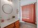Bright bathroom with wainscoting, round mirror, and tile floors at 13025 Lake Roper Ct, Windermere, FL 34786