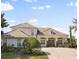 Beautiful two-story home featuring lush landscaping, a tile roof, and a welcoming front entrance at 13025 Lake Roper Ct, Windermere, FL 34786