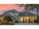 Elegant home featuring a tile roof, inviting front porch, and meticulously maintained landscaping at 13025 Lake Roper Ct, Windermere, FL 34786