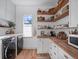 Laundry room with stainless washer/dryer, wood countertops, and wood shelving at 13025 Lake Roper Ct, Windermere, FL 34786