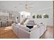 Open-concept living room with hardwood floors, ceiling fan, staircase, and a view into the kitchen at 13025 Lake Roper Ct, Windermere, FL 34786