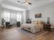 Spacious main bedroom with tray ceiling, ceiling fan, bench, sitting chairs, and large windows at 13025 Lake Roper Ct, Windermere, FL 34786
