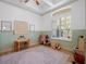 Bright playroom with a light wood floor, a pink patterned rug, and lots of natural light from a shuttered window at 13025 Lake Roper Ct, Windermere, FL 34786