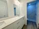 Modern bathroom featuring dual sinks, white quartz countertop, and a marble tiled shower visible through doorway at 1304 Hillsborough Ct, Kissimmee, FL 34759