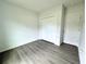 A bright bedroom with wood-look floors, double closet, and white trim, providing a functional living space at 1304 Hillsborough Ct, Kissimmee, FL 34759